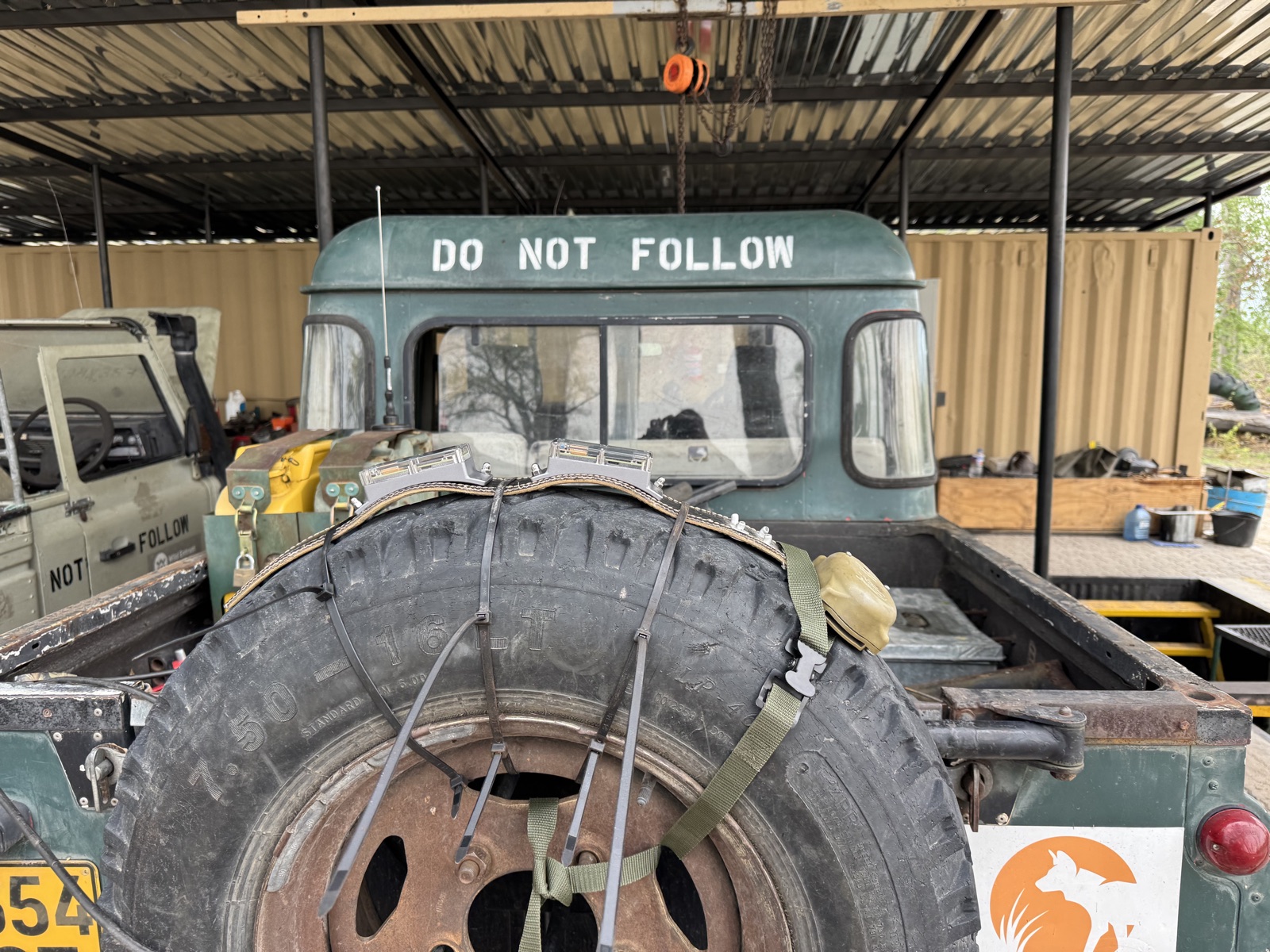 Two CollarIDs cable-tied to the spare wheel on the back of a green Land Rover, for a radio range test