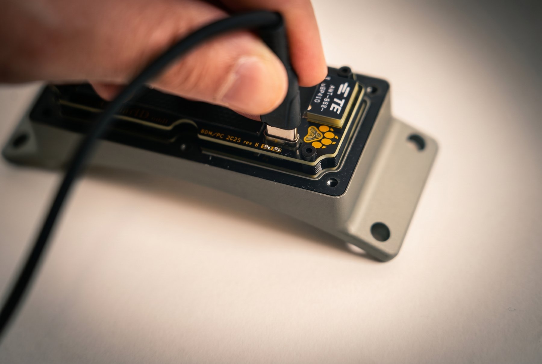 USB-C cable plugged into the device with the cover removed
